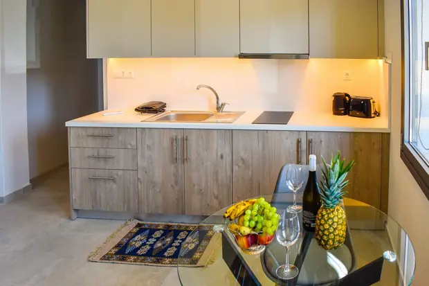 Kitchen worktop with hob and sink, fruit and wine on the table
