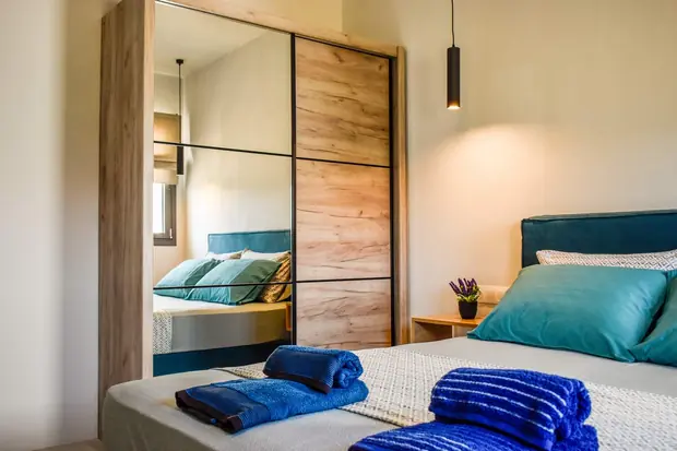The mirrored wardrobe reflecting the bed